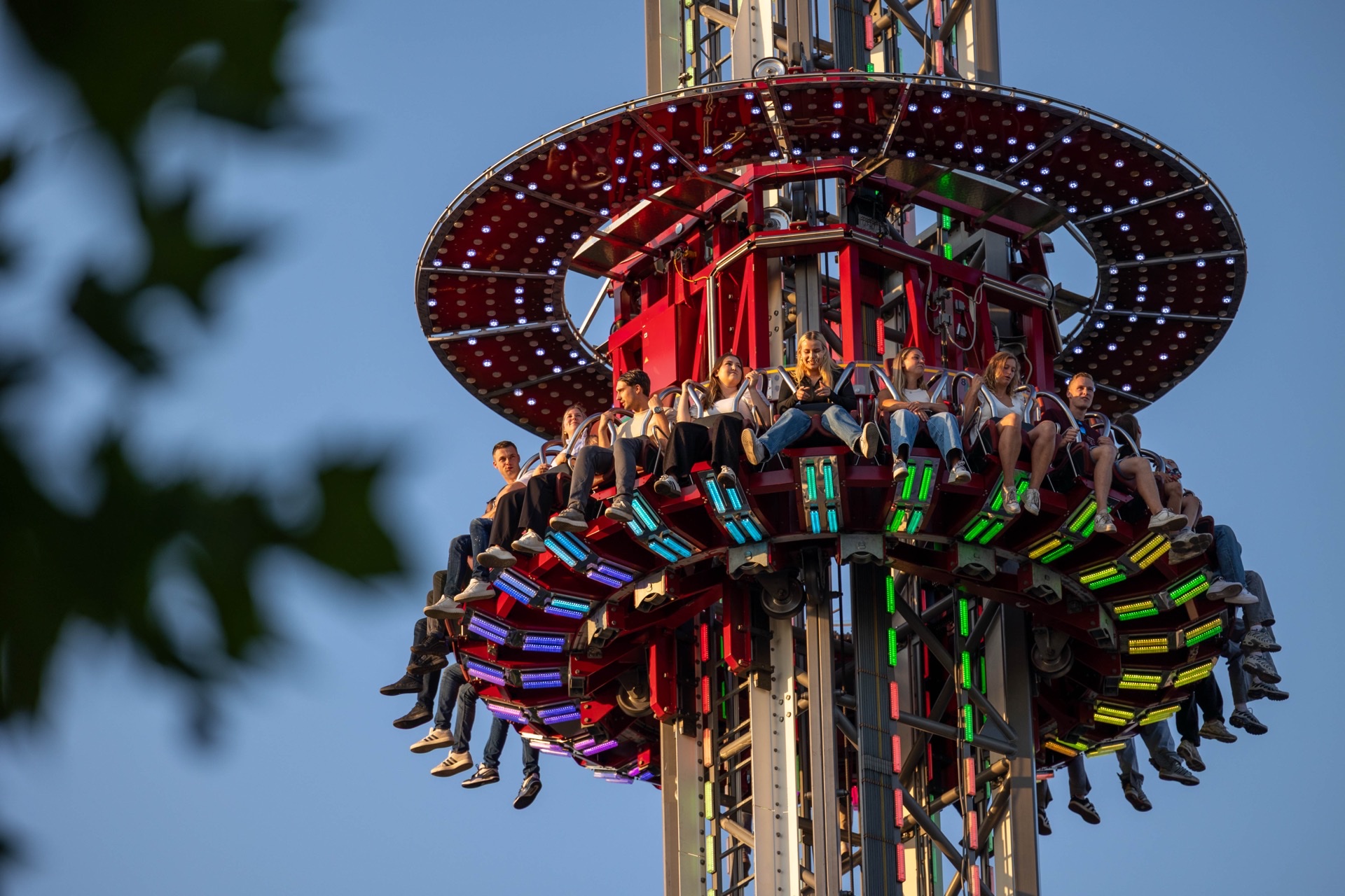 Drop tower met kleurrijke kermisverlichting boven Tilburg